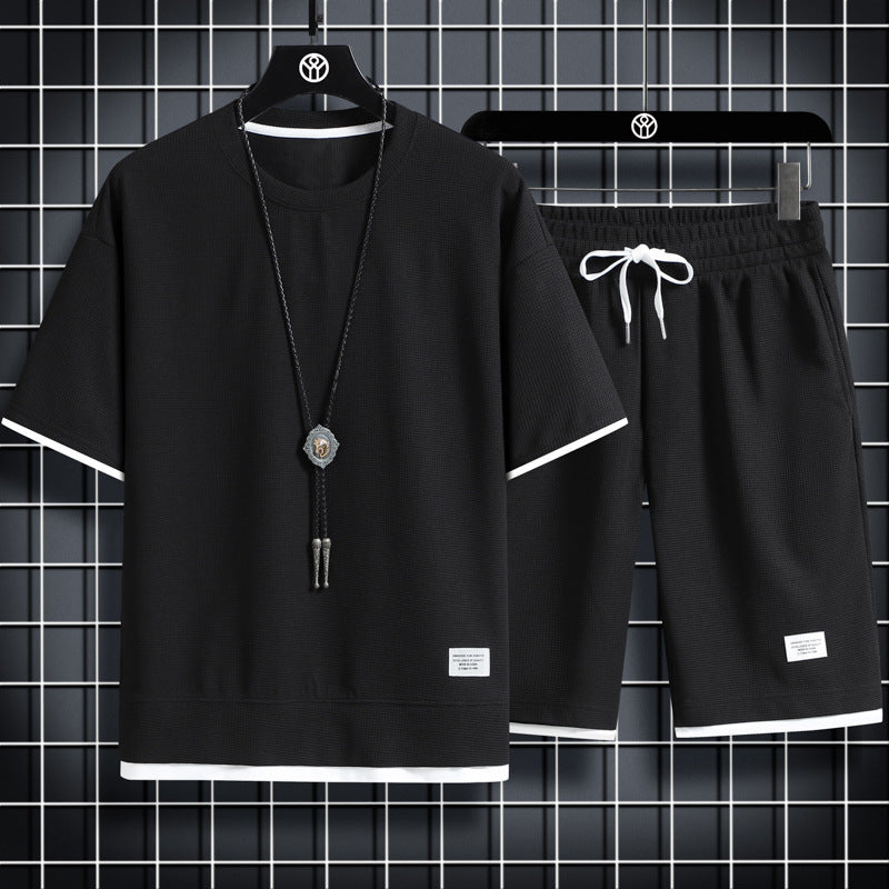 Black t-shirt and shorts set with decorative elements on hangers against a grid background