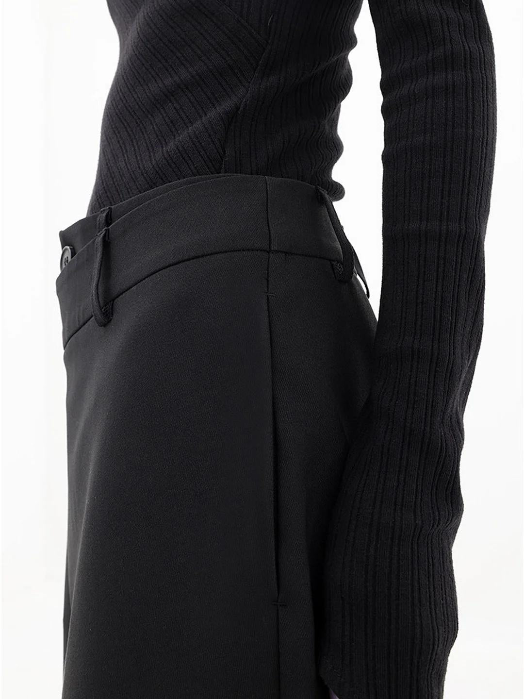 Close-up of the button closure at the asymmetrical waistband of the modern baggy pants.