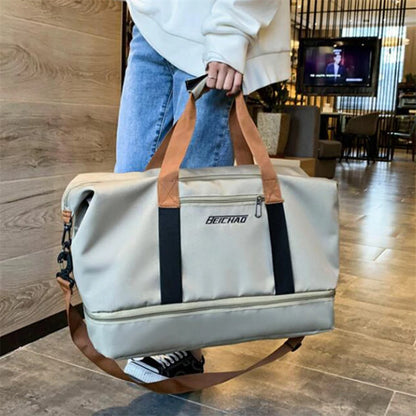 Person holding grey duffle bag by the handles, showcasing its comfortable grip and stylish design for easy carrying. 