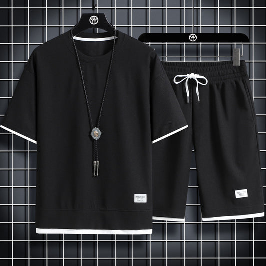 Black t-shirt and shorts set with decorative elements on hangers against a grid background